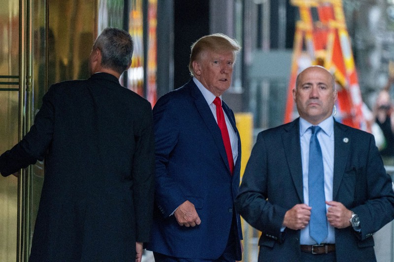 「マララーゴ」が家宅捜索を受けた2日後、トランプタワーを出発するトランプ前米大統領(中央)=ニューヨークで2022年8月10日、ロイター