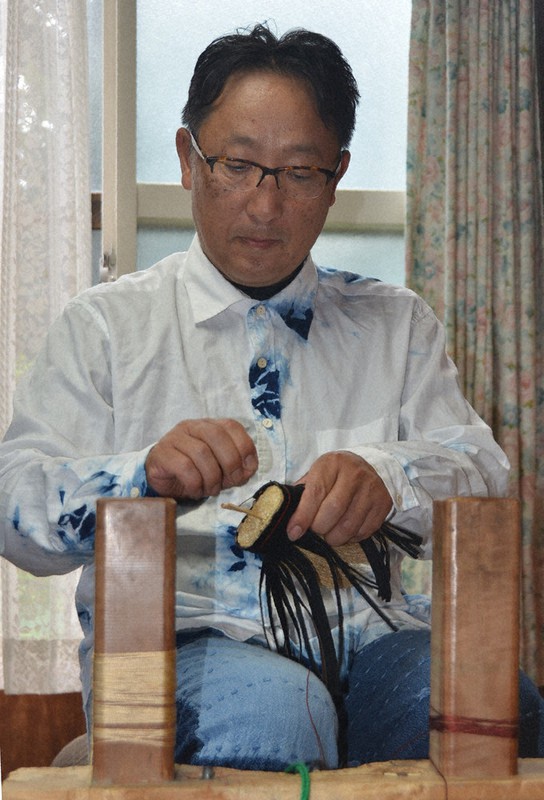 一つずつ丁寧に箒を編んでいく高倉清勝さん=岩手県九戸村の高倉工芸で2022年7月28日、湯浅聖一撮影