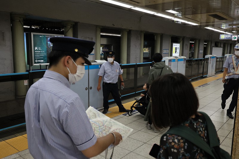大雨で線路の一部が冠水たため運転見合わせとなった東西線の九段下駅で乗客に説明する駅員ら=東京都千代田区で2022年9月18日午後2時44分、和田大典撮影