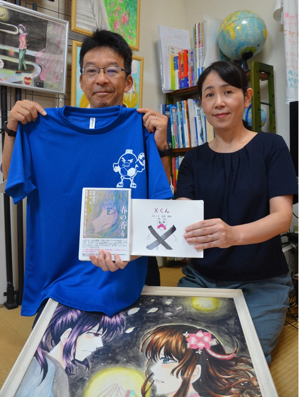 坂野春香さんの絵本や出版した書籍を手にする和歌子さん(右)と貴宏さん=愛知県江南市で