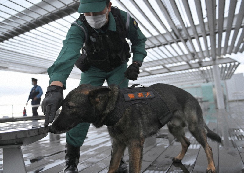 空港の展望デッキを調べる警察官と警備犬=羽田空港で2022年9月24日、前田梨里子撮影