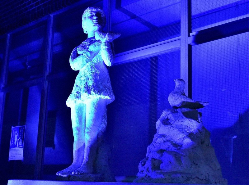 青い光に浮き上がる「鳩をだいた少女の像」=埼玉県小鹿野町で2022年9月23日午後5時54分、山田研撮影