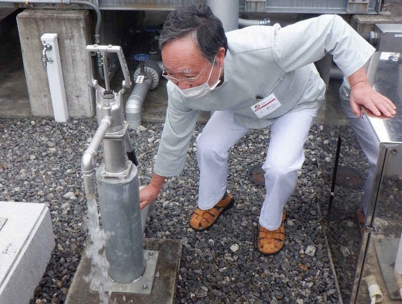 敷地内の井戸から水をくみ上げる杉山寿一院長=静岡市清水区の杉山クリニックで2022年9月29日、五十嵐和大撮影