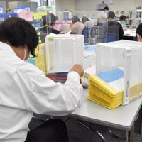 特例貸し付けの返済に関する書類を扱うスタッフら＝東京都千代田区の東京都社会福祉協議会特例貸付事務センターで2022年8月9日午後5時38分、中川友希撮影