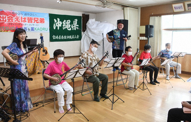 「波島三線クラブ」のメンバーと一緒に演奏する宮村さん（中央奥）と照屋さん（左端）