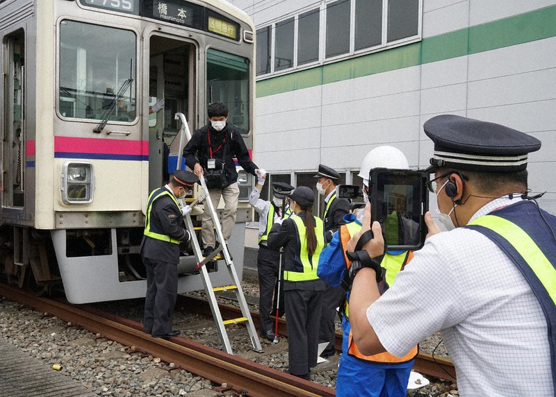 事故列車から乗客を避難させる状況を「バディコム」のタブレットを使って関係部署に送る係員(右端)=京王電鉄若葉台車両基地で