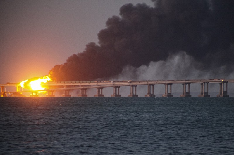 ロシア本土とクリミア半島を結ぶクリミア大橋から広がる炎と黒煙=2022年10月8日、AP