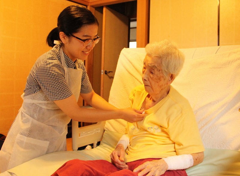 患者の自宅を訪れ、体の状態を確認する訪問看護師（右）＝東京都世田谷区で2017年6月（本文とは関係ありません）