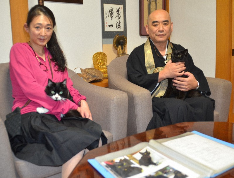 蚶満寺で飼っている猫を抱く住職の熊谷右忍さん(右)と妻有生さん=秋田県にかほ市で2022年10月10日、工藤哲撮影