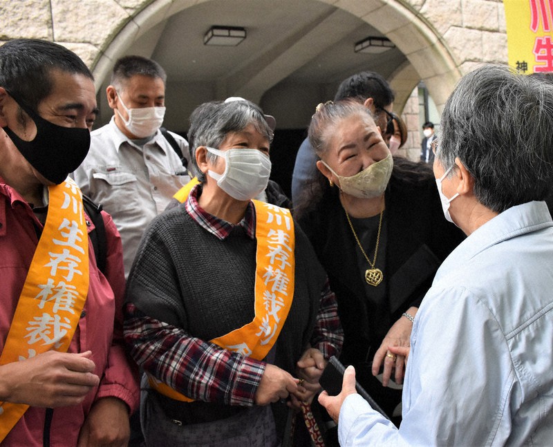 生活保護費引き下げを取り消す判決が出され、笑顔を見せる原告団ら=横浜市中区の横浜地裁前で2022年10月19日午前11時41分、田中綾乃撮影