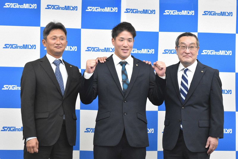 岡崎淳二監督(左)と栁川壽夫部長(右)の間でガッツポーズする小孫投手=埼玉県狭山市で2022年10月20日午後7時、南茂芽育撮影