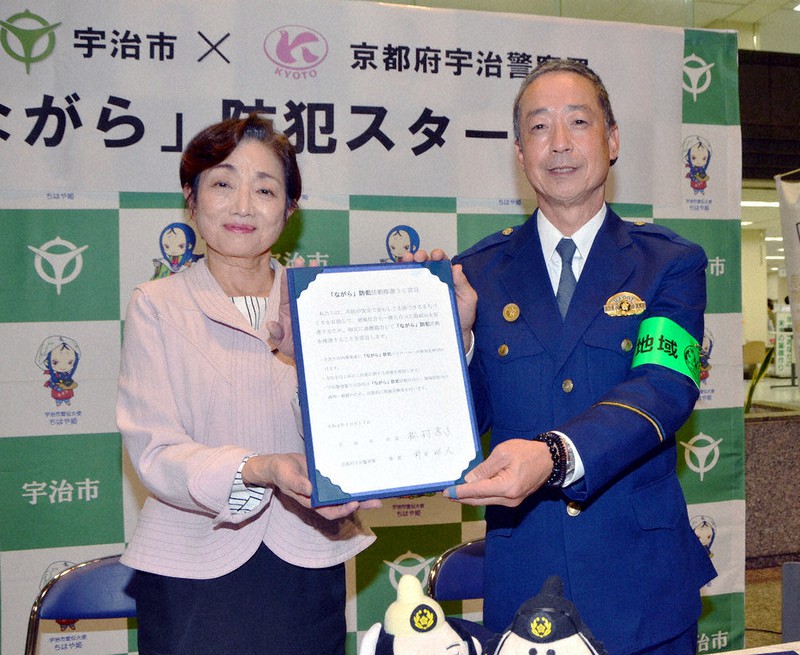 「『ながら』防犯活動推進うじ宣言」を示す松村淳子・京都府宇治市長(左)と前田昭人・京都府警宇治署長=同市役所で、鈴木健太郎撮影