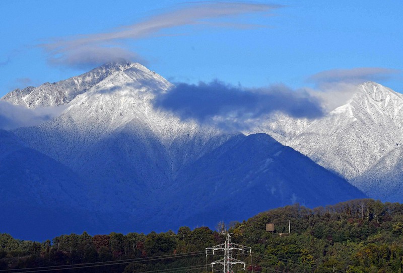 雪化粧した北アルプスの常念岳(左)と横通岳=長野県松本市浅間温泉で、武田博仁撮影