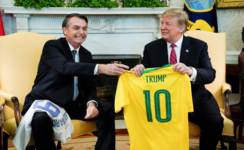 2019年3月19日、トランプ米大統領(右、当時)にサッカー・ブラジル代表のジャージーをプレゼントするブラジルのボルソナロ大統領=米ホワイトハウスで、ロイター