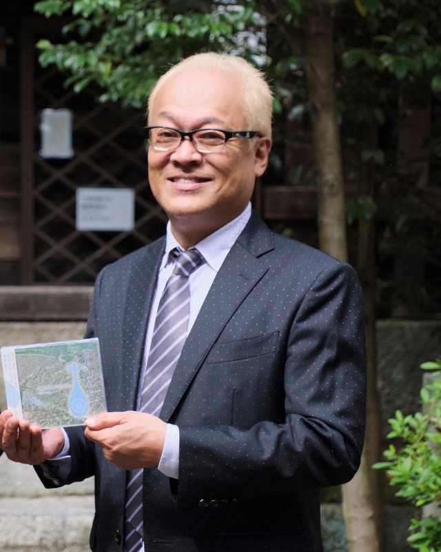 奉納曲のCDを手に「関蝉丸神社下社のことを多くの人に知ってもらいたい」と語るエイコン・ヒビノさん(本人提供)
