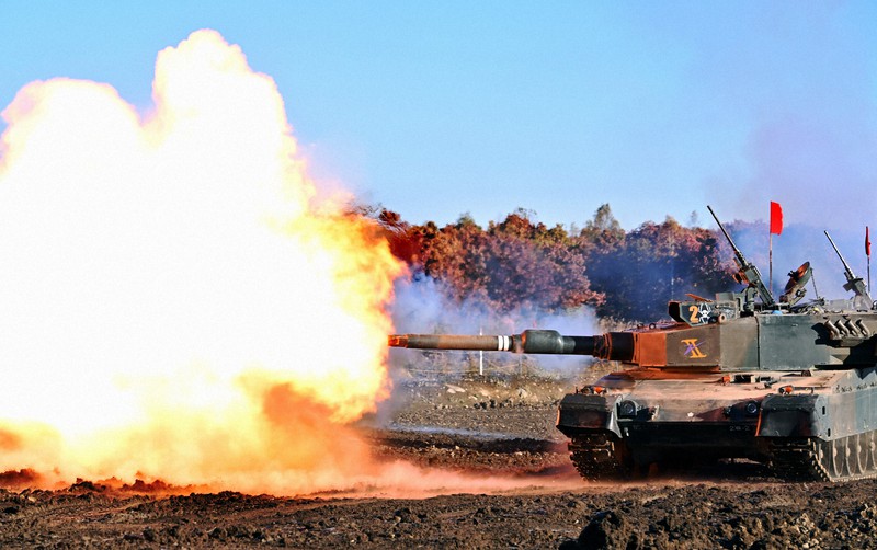 主砲の発射炎で赤く染まった陸上自衛隊の90式戦車=北海道恵庭市の北海道大演習場島松地区で2022年10月26日、岩下幸一郎撮影