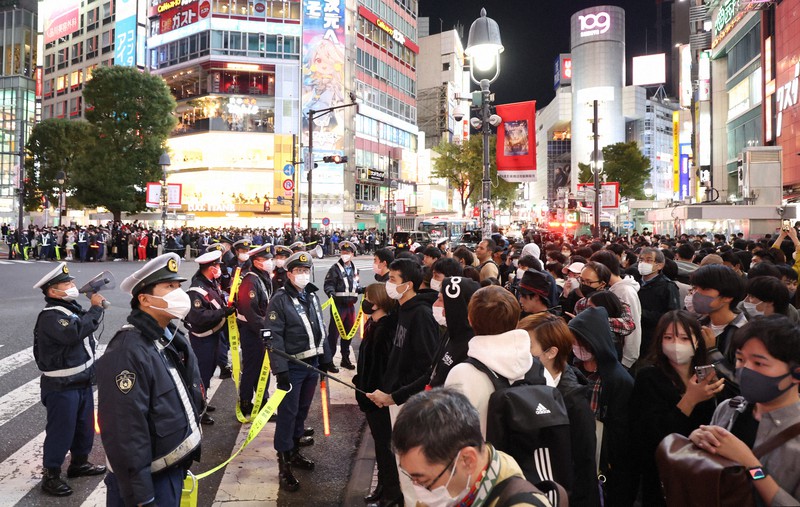 警察官が警備する中、大勢の歩行者で混み合う渋谷駅前のスクランブル交差点=東京都渋谷区で2022年10月30日午後7時10分、小出洋平撮影