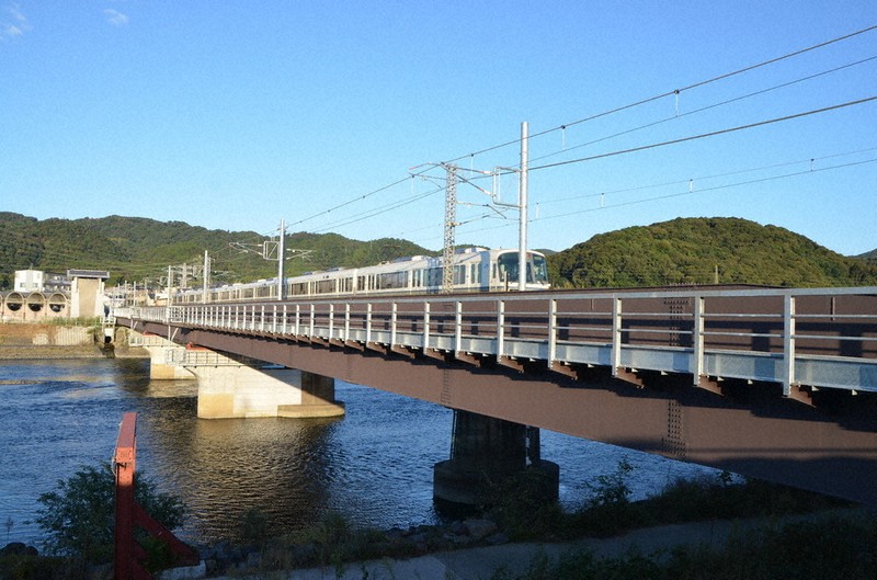 JR奈良線の複線化で宇治川に架けられた新しい橋(手前)。電車が走っているのは、現在単線として使用されている既存の橋=京都府宇治市内で、鈴木健太郎撮影