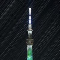 東京スカイツリーの背後に昇る星々の光跡。2時間弱にわたり、2秒露光で撮影した画像2800枚を比較明合成して1枚の写真にしている＝東京都台東区で2022年10月20日