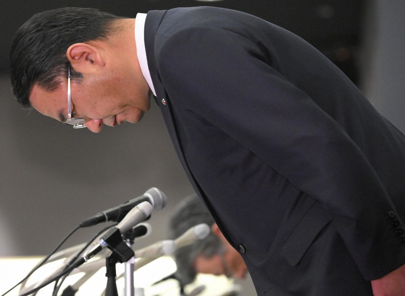 記者会見で頭を下げて謝罪するSMBC日興証券の近藤雄一郎社長。奥は猪瀬真哉常務執行役員=東京都千代田区で2022年3月24日午後、宮間俊樹撮影
