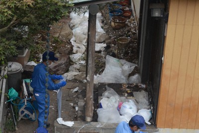 行政代執行でごみ屋敷からごみを運び出す作業員ら。このようなごみ屋敷は例外的な存在で、強制的な対応をする前の支援が重要だという＝神奈川県横須賀市船越町で2018年8月28日、岩崎信道撮影