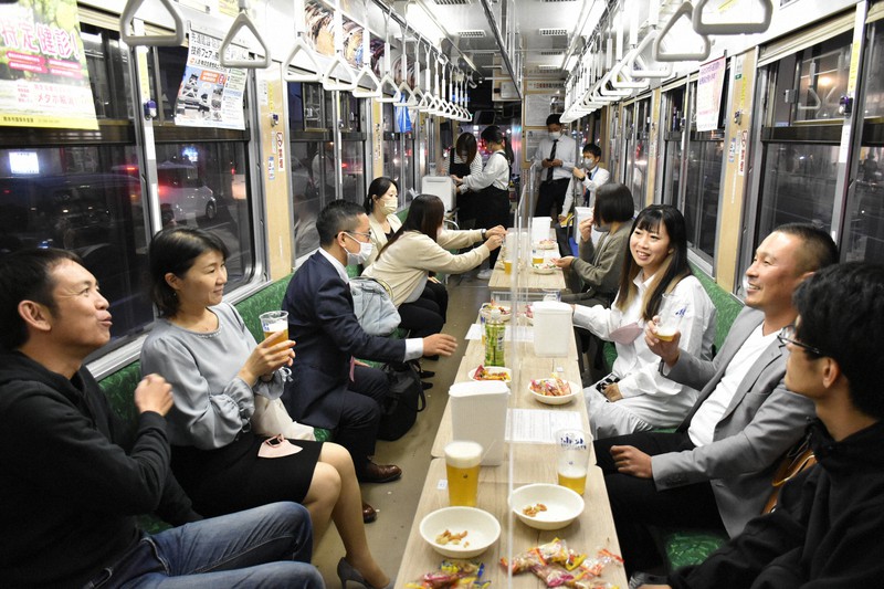 熊本市電に乗って街中を走りながらビールを楽しむ「ビアガー電」の乗客ら=熊本市中央区で2022年11月4日午後5時39分、栗栖由喜撮影