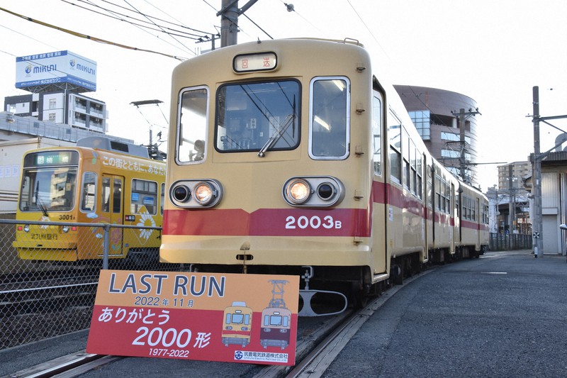 ラストランを終え車庫に入った2000形車両。左奥は乗客を乗せて走る現役の3000形車両=北九州市八幡西区黒崎3で2022年11月7日午後4時12分、成松秋穂撮影