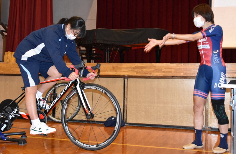 杉浦さん(右)の声援を受けて自転車をこぐ生徒=静岡県掛川市の市立大浜中学校で2022年11月7日午後3時5分、山田英之撮影