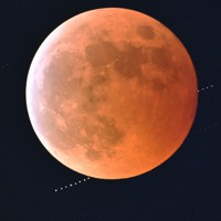皆既月食中の満月の背後に隠れる天王星（左下）＝東京都墨田区で2022年11月8日、手塚耕一郎撮影（午後8時25分から2分間隔で撮影した9枚を合成）