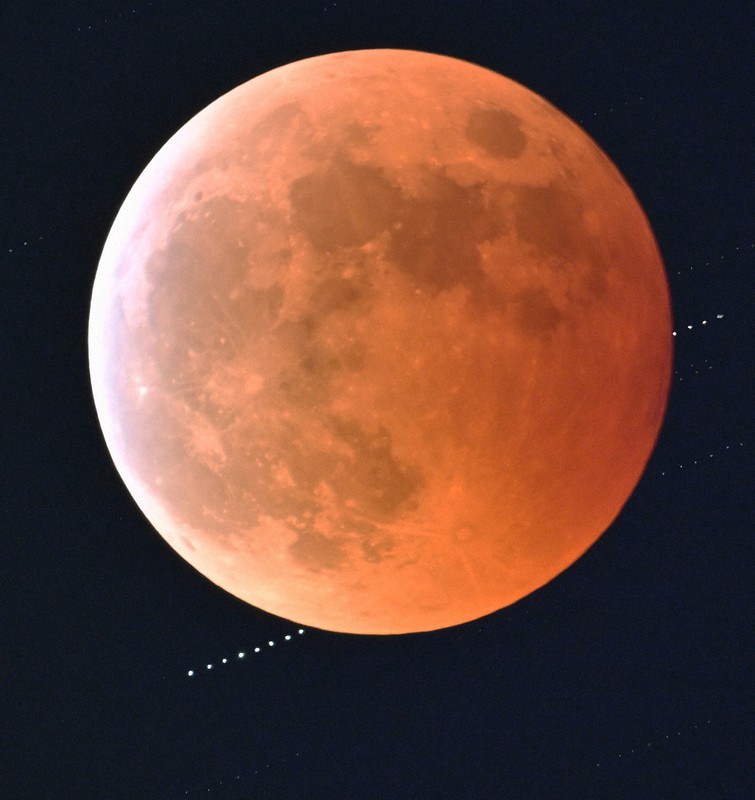 皆既月食中の満月の背後に隠れる天王星（左下）＝東京都墨田区で2022年11月8日、手塚耕一郎撮影（午後8時25分から2分間隔で撮影した9枚を合成）