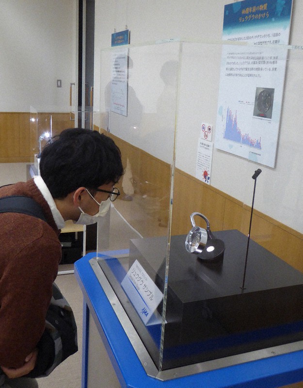 展示されたリュウグウのかけらに見入る来場者=京都市北区で2022年11月9日午前10時35分、千葉紀和撮影