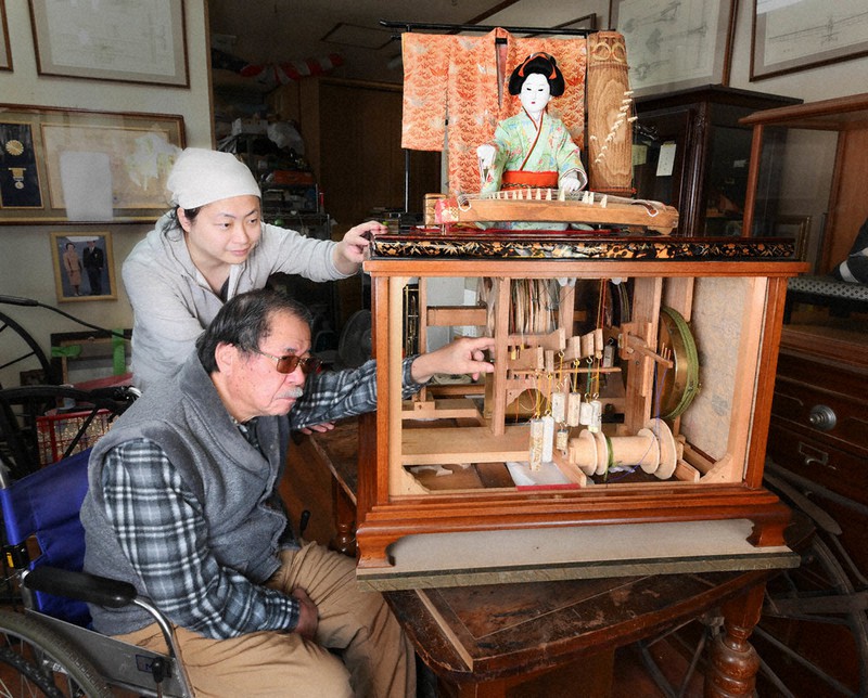 琴弾き人形の仕掛けを確認する東野進さん(手前)と秀規さん。完成まで何万回も調整をしたという=大阪府寝屋川市で、北村隆夫撮影