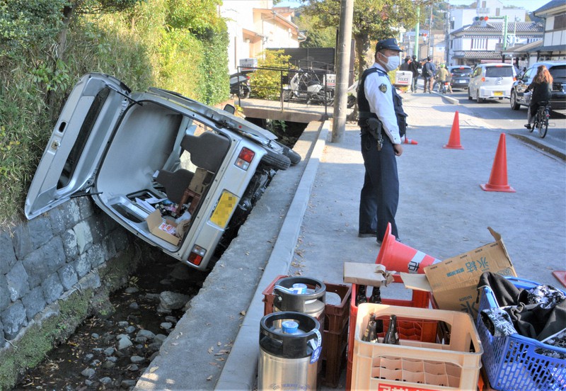 鶴岡八幡宮前の信号(右上端)近くの堀に転落した軽自動車=神奈川県鎌倉市で2022年11月11日午後2時1分、因幡健悦撮影(画像の一部を加工しています)
