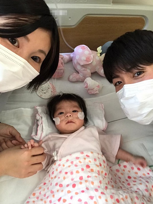 幸音ちゃん(中央)の付き添いを交代する父の聡志さん(右)と妻。二人が顔を合わせることができるのは、このタイミングだけだ=家族提供(画像の一部を加工しています)
