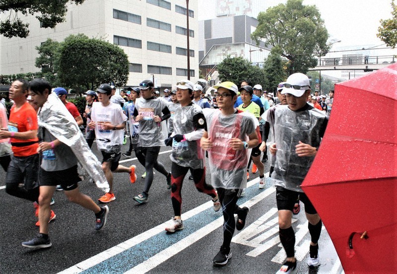 雨対策を施しながら駆けるランナーたち=岡山市北区で2022年11月13日午前9時31分、相原洋撮影