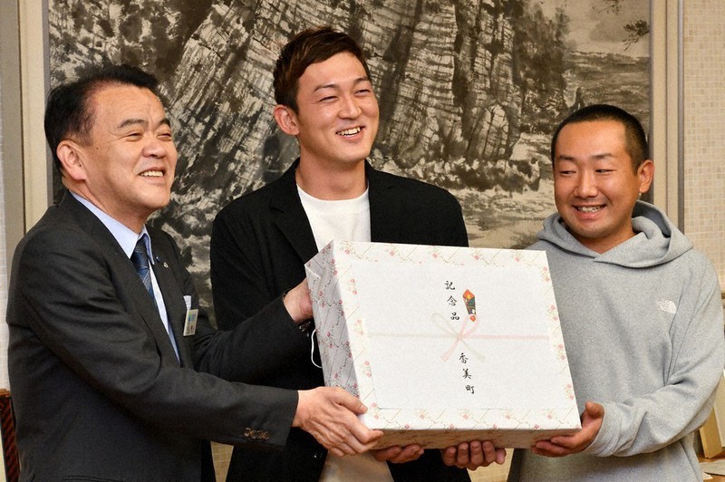 浜上勇人町長(左)から激励の記念品を渡される房安晋也さん(中央)と神稔典さん=兵庫県香美町役場で、浜本年弘撮影