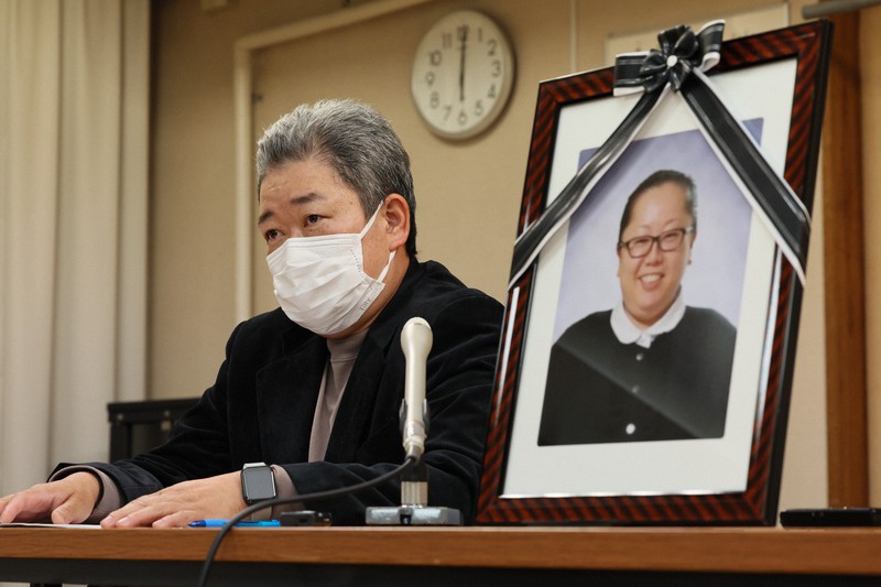 ワクチン接種直後に亡くなった飯岡綾乃さんの遺影を横に記者会見する夫英治さん=愛知県愛西市で2022年11月17日午後6時、兵藤公治撮影