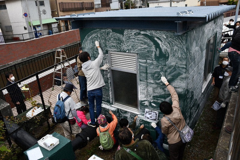 ポンプ場の側壁にチョークでさまざまな水の模様を描く市民たち=千葉県浦安市で2022年11月20日、石塚孝志撮影