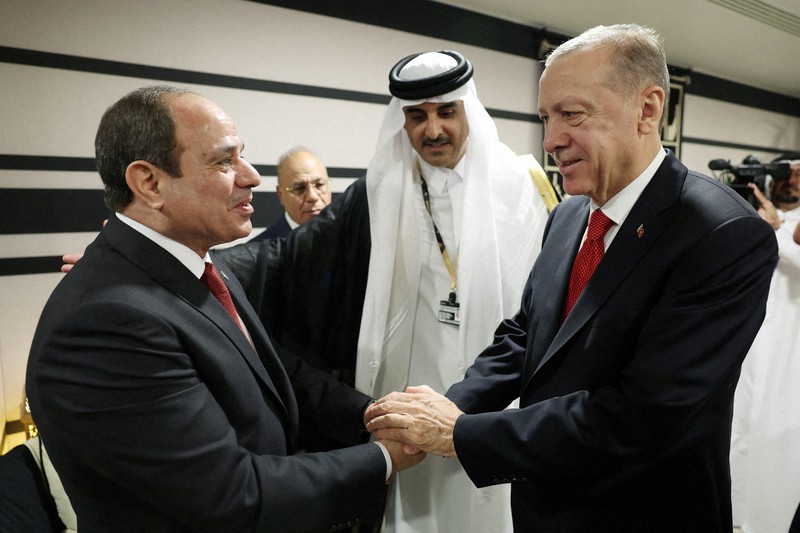 エジプトのシシ大統領(左)と握手を交わすトルコのエルドアン大統領=カタールの首都ドーハで20日、ロイター