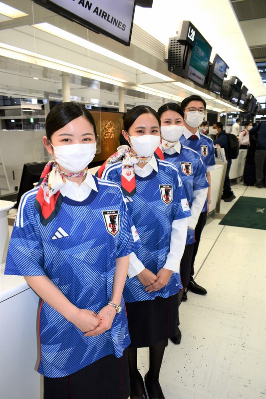 日本代表のレプリカユニホームを着用する日本航空の地上旅客係員=千葉県成田市の成田空港で2022年11月21日午後0時2分、中村宰和撮影