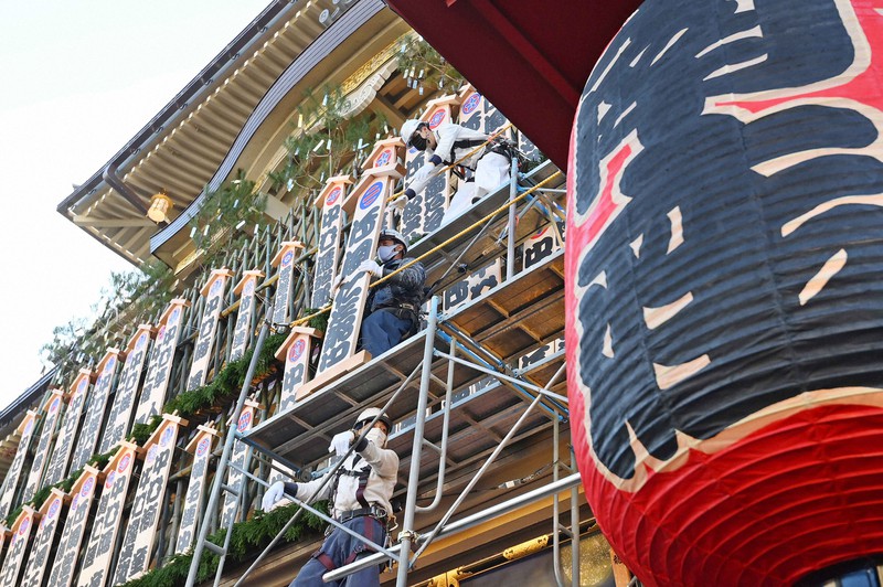 吉例顔見世興行を前に、出演する役者の名前が書かれた看板を掲げる「まねき上げ」=京都市東山区で2022年11月25日午前9時1分、山崎一輝撮影