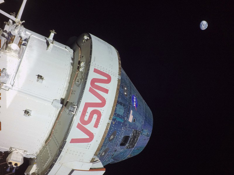宇宙船オリオンの太陽電池パネルに取り付けられたカメラがとらえた画像。右上に地球が見える=2022年11月26日、米航空宇宙局提供