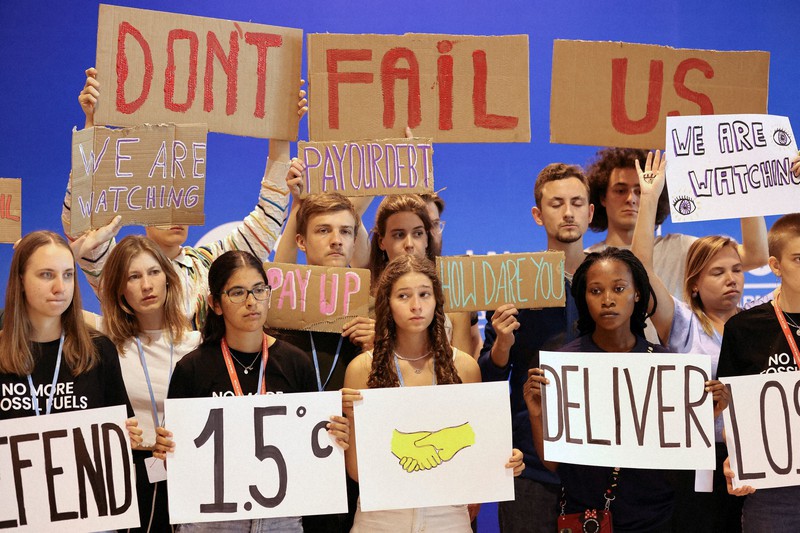 COP27で「1・5度を守れ」「私たちを裏切らないで」などと書かれたメッセージボードを掲げる若者たち=エジプト東部シャルムエルシェイクで2022年11月19日、ロイター