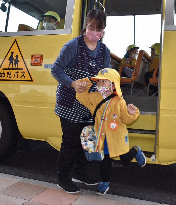園児一人一人と手をつないでバスから降ろす職員=岐阜県本巣市下真桑の同市立真桑幼児園で2022年11月30日午前9時11分、黒詰拓也撮影