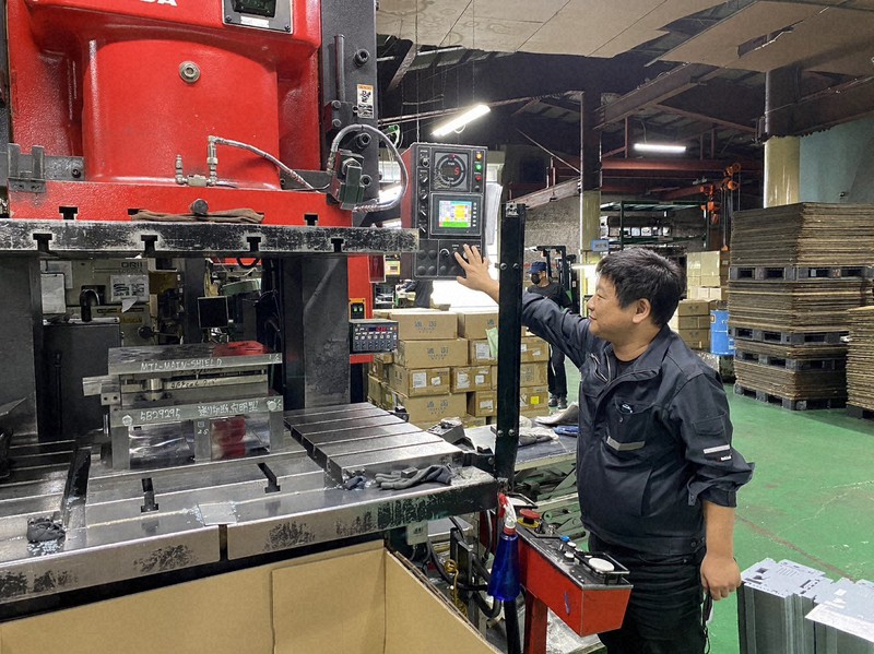 金属プレス機を操作する大和金属工業の橋本孔志社長。節電のためにできるだけ設備の電源をオフにしている=福井県越前市の大和金属工業福井工場で(同社提供)
