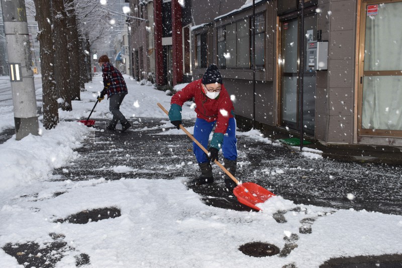 雪が降る中、自宅前の雪かきに追われる市民=青森市安方で2022年12月1日午後3時37分、江沢雄志撮影