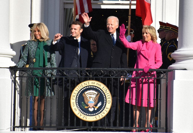 米ホワイトハウスのバルコニーから、集まった聴衆に手を振るバイデン米大統領夫妻(右側)とフランスのマクロン大統領夫妻=2022年12月1日、秋山信一撮影