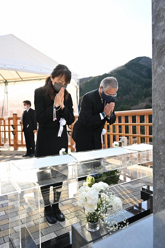 トンネル近くの慰霊碑に手を合わせる遺族ら=山梨県大月市で2022年12月2日(代表撮影)