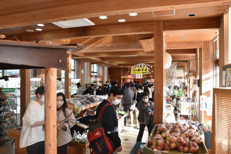 出雲三成駅に到着し、駅舎内の仁多特産市で買い物を楽しむ乗客たち=島根県奥出雲町で2022年11月2日午後3時0分、松原隼斗撮影