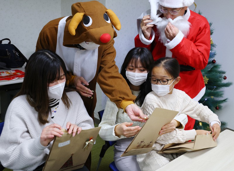 クリスマスパーティーでプレゼントをもらい喜ぶ参加者たち=東京都江東区で2022年12月3日午後5時11分、猪飼健史撮影